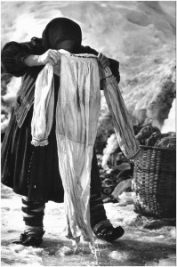 Eine rumänische Frau wäscht die Wäsche ihrer Familie im Eisloch. (Desești, Rumänien,1973)