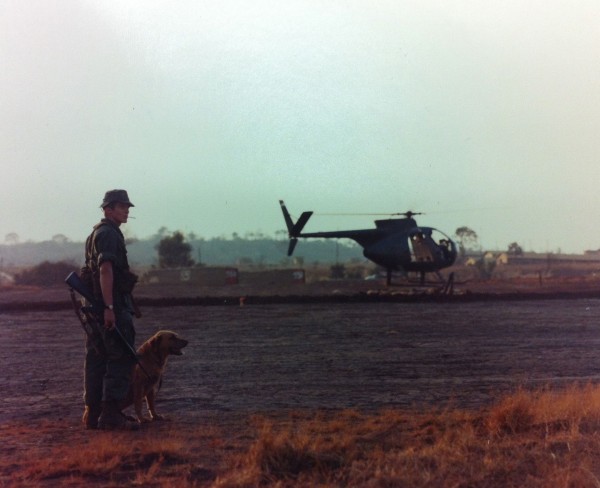 Abb. 8: Vietnam: A dog handler (...) and his dog wait at a helipad for an early evening flight to a combat area, Official U.S. Army Photo (Releases), National Archives Washington, 111-CCV-459E