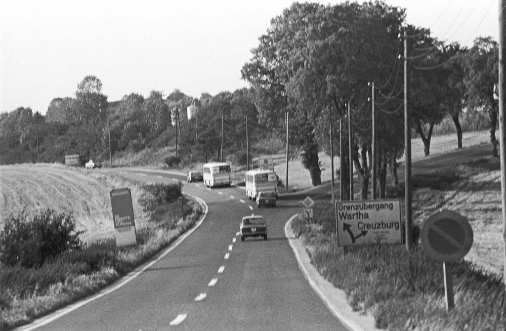 „Freikauf politischer DDR-Haeftlinge. Wartha (Bezirk Erfurt) DDR, 14. 09. 1977. Foto: Autobusse mit Freigekauften, Begleitfahrzeuge bei Einfahrt in die Sperrzone vor der Grenze. Die Bundesrepublik kauft der DDR politische Gefangene gegen Devisen ab. Der Transport der freigekauften Haeftlinge fuehrt vom Entlassungsgefaengnis ueber die Transitautobahn in das Notaufnahmelager Giessen. Am Grenzuebergang steigen die Begleiter des Ministeriums fuer Staatssicherheit (MfS, Stasi) in die den Konvoi begleitenden Fahrzeuge um. Die fuer den Handel angeschafften Autobusse haben drehbare Kennzeichen und sind in beiden Staaten zugelassen.“ © Bundesstiftung Aufarbeitung, Klaus Mehner, 77_0914_POL-Freikauf_20